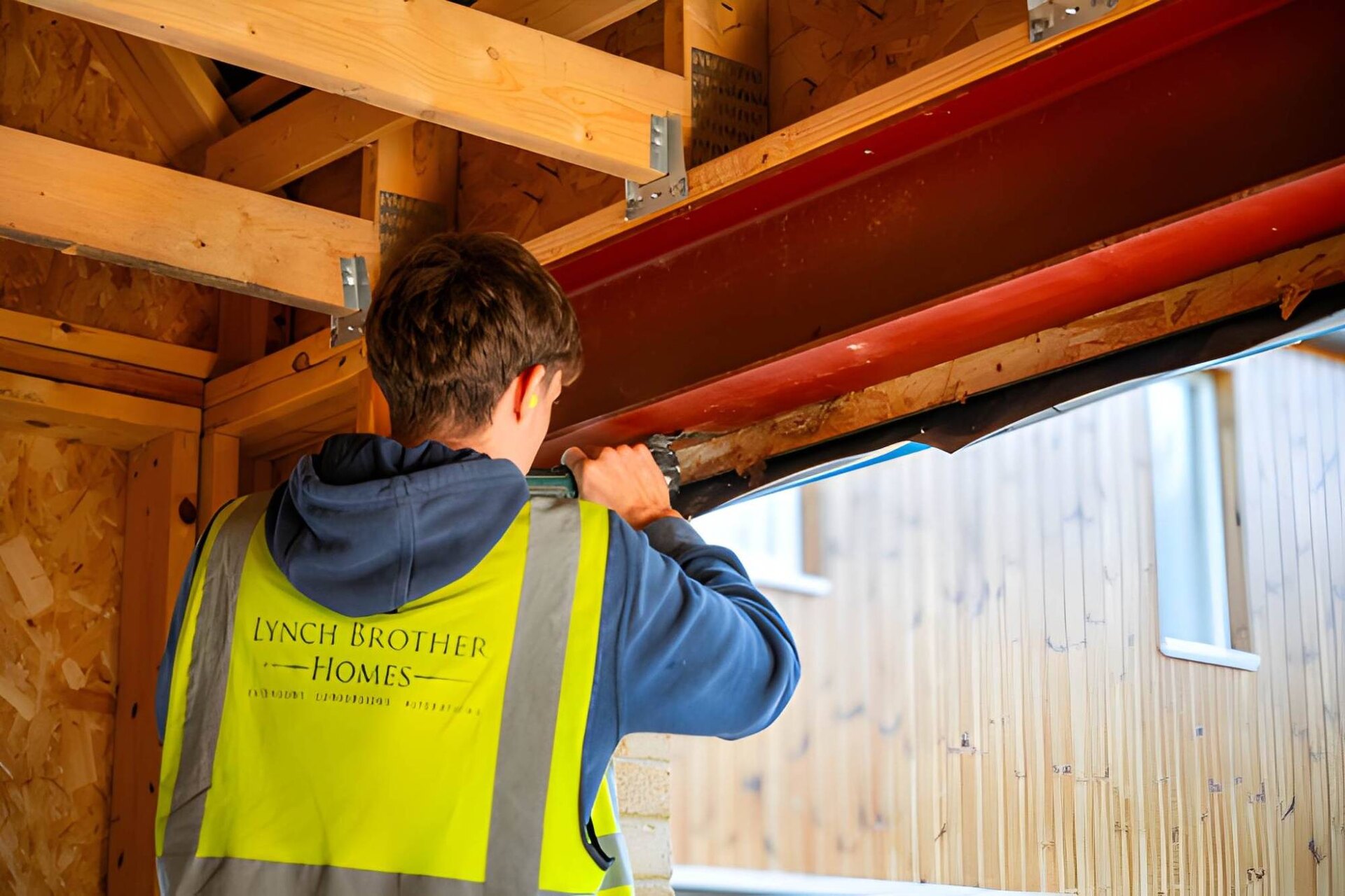A Lynch Brother Homes carpenter fixing a steel beam into a new timber frame